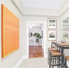  ??  ?? A pop of orange in the form of artwork helps add colour to this kitchen nook.