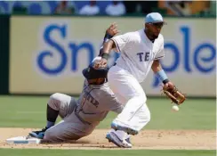  ?? Associated Press ?? Texas Rangers shortstop Elvis Andrus bobbles the throw to the bag Sunday as Seattle Mariners' Robinson Cano steals second in the fifth inning of a baseball game in Arlington, Texas.