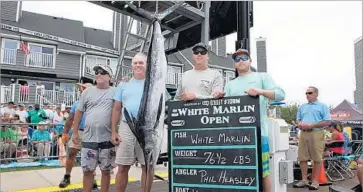  ?? Hooked on OC ?? PHILIP G. HEASLEY, second from left, poses with the white marlin that earned him the $2.8-million top prize in a fishing contest off the Maryland coast. Heasley and three others on his boat failed polygraph tests.