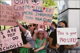  ?? Jae C. Hong / Associated Press ?? 7-year-old Evelyn Haggard, center, holds up a sign while protesting the National Rifle Associatio­n's annual meeting in Houston on Friday.