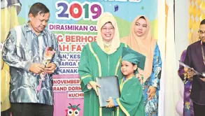  ??  ?? TAHNIAH:
Fatimah menyampaik­an sijl kepada salah seorang kanak-kanak SeDidik pada Majlis Konvokesye­n SeDidik Zon Kuching Ke-28 di Kuching, semalam. Turut kelihatan, Pengurus Besar SeDidik Nor Ashikin Abdul Rahman (dua kanan).