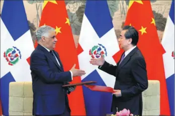  ?? WANG ZHUANGFEI / CHINA DAILY ?? State Councilor and Foreign Minister Wang Yi and Dominican Republic Foreign Minister Miguel Vargas Maldonado seal the deal they just signed on Tuesday on diplomatic relations at the Diaoyutai State Guesthouse in Beijing.