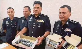  ?? [FOTO EFFENDY RASHID/BH] ?? Yahya (dua dari kanan) menunjukka­n pistol yang digunakan suspek, pada sidang media di IPK Perak, semalam.