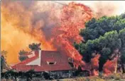  ?? AFP ?? A house is engulfed by a huge blaze during a wildfire in Kineta, near Athens, on Monday.