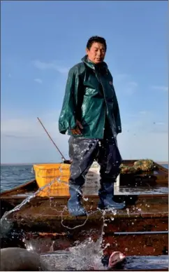  ?? PHOTOS BY HU HUHU / XINHUA ?? Chen Guishan on his boat in the Ulungur Lake.