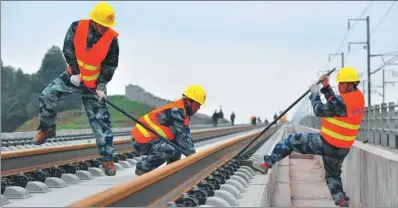  ?? CAO NING / FOR CHINA DAILY ?? Workers from China Railway Constructi­on Group lay tracks along the Chengdu-Guiyang high-speed railway line.