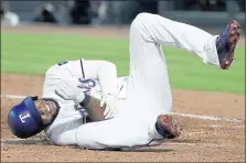  ?? TONY GUTIERREZ — THE ASSOCIATED PRESS ?? Texas’ Elvis Andrus rolls on the ground by home plate holding his right elbow after being hit by a pitch from the Angels’ Keynan Middleton on Wednesday. Andrus is out for 6to 8weeks because of a broken elbow.