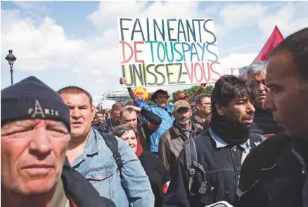  ?? THIBAULT CAMUS ASSOCIATED PRESS ?? Sur les pancartes, le président Macron était ciblé, comme ici à Paris, pour ses propos dans lesquels il promettait de ne céder «ni aux fainéants, ni aux cyniques, ni aux extrêmes».