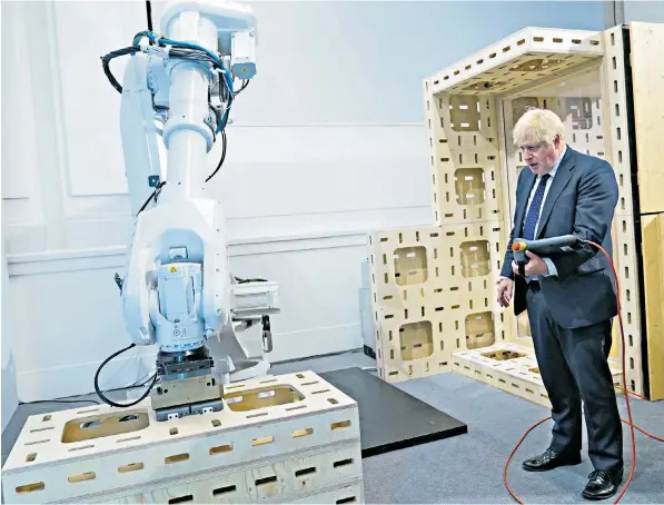  ?? ?? Boris Johnson operating a robot arm during a visit to the Innovation Zone of the Global Investment Summit at the Science Museum in London