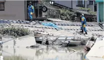  ?? PHOTO: REUTERS ?? Aftermath . . . Police officers check submerged and destroyed houses in a flooded area in Mabi town in Kurashiki, Okayama Prefecture, Japan, yesterday.