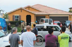  ?? Bill Wechter / AFP / Getty Images ?? Residents of Perris (Riverside County) watch as media gather in front of the home where 13 children and young adults were suspected of being held captive.