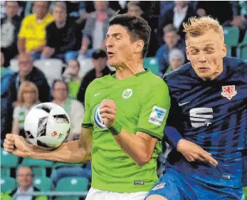  ?? FOTO: DPA ?? Klarer geht es nicht: Auch wenn es keine Absicht war, nimmt Wolfsburg Stürmer Mario Gomez hier im Duell mit Saulo Decarli unerlaubte Hilfe in Anspruch. Sekunden später bekam er einen Elfmeter, Gomez verwandelt­e.