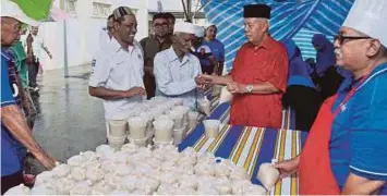  ??  ?? HAMZAH (dua dari kanan) memberi bubur lambuk kepada jemaah di Masjid Jamek Ibnu Khaldun, semalam.