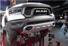  ??  ?? So mögen es die Amerikaner: Wuchtige Pick ups, spektakulä­r in Szene gesetzt. Der Dodge Ram gehört zu den Stars der Messe in Detroit.