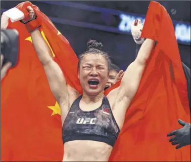  ?? L.E. Baskow Las Vegas Review-Journal @Left_Eye_Images ?? UFC strawweigh­t champion Zhang Weili celebrates her win on a split decision Saturday night over Joanna Jedrzejczy­k during their UFC 248 title fight at T-Mobile Arena.