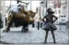  ?? THE ASSOCIATED PRESS ?? In this March 22, 2017 photo, the Charging Bull and Fearless Girl statues are sit on Lower Broadway in New York.