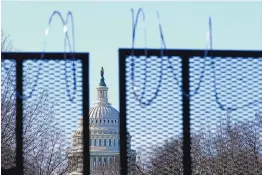  ?? PATRICK SEMANSKY/ASSOCIATED PRESS ?? The U.S. Capitol dome stands past partially removed razor wire hanging from a security fence. Authoritie­s suggested for weeks in court hearings and papers that members of the Oath Keepers militia group planned their attack in advance.