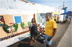  ?? NELVIN C. CEPEDA U-T ?? Kim Phillips-Pea (derecha) y Raquel Rhone del Equipo de Arte del Sureste se toman un breve descanso de la pintura de un gran proyecto de murales en Lincoln Park.