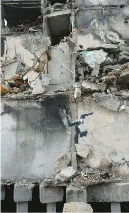  ?? ANDREW KRAVCHENKO/AP ?? Art amid the war in Ukraine: A delicate black-and-white painting of a gymnast doing a handstand graces the wall of a wrecked building Sunday outside of Kyiv and appears to be the work of the British graffiti artist known as Banksy. The artist posted photos on his Instagram page of the artwork in Borodyanka, northwest of Ukraine’s capital.