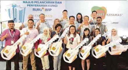  ?? PIC BY SADDAM YUSOFF ?? Federal Territorie­s Minister Datuk Seri Tengku Adnan Tengku Mansor (second row, third from right) with 10 of the early recipients of the completed units of Rumawip Residensi Sentulmas in Kuala Lumpur yesterday. With him is Mayor Tan Sri Mhd Amin Nordin...