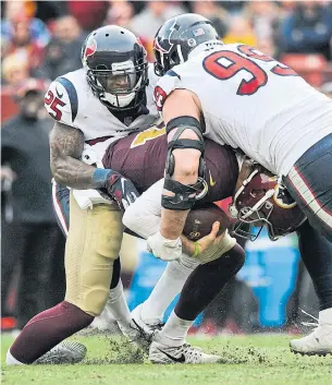  ?? MARK TENALLY THE ASSOCIATED PRESS ?? Washington Redskins quarterbac­k Alex Smith is injured as he’s sacked by Houston Texans J.J. Watt, right, and Kareem Jackson on Sunday in Landover, Md. Smith broke two bones.