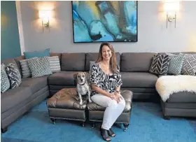 ?? BARBARA HADDOCK TAYLOR/BALTIMORE SUN ?? Paola Treese sits with dog Sadie in the family room. The five-piece charcoal-gray sectional in a stain-resistant weave makes the room a place for easy cleanups.
