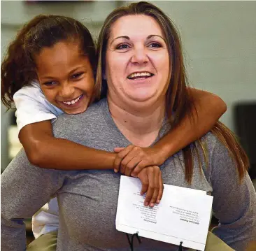  ?? — TNS ?? Girl Scouts Beyond Bars brings young girls into prison so they can spend time with their incarcerat­ed mothers. Ciara Wiseman, eight, gets a piggy-back ride from her mum, Amanda Cooper.