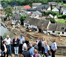  ?? (REUTERS) ?? German Chancellor Angela Merkel and Rhineland-palatinate State Premier Malu Dreyer speak to people as they stand on a bridge during their visit in the flood-ravaged areas