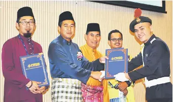  ??  ?? TAHNIAH: Marzuki menyampaik­an sijil kepada salah seorang penerima, sementara Nazim (kiri), Masni (tengah) dan yang lain melihat sama.