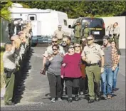  ?? Mel Melcon Los Angeles Times ?? CMDR. Christophe­r Dunn escorts relatives of Sheriff's Sgt. Ron Helus at the coroner’s office in Ventura.