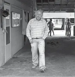  ?? CHARLIE RIEDEL/AP ?? Trainer Steve Asmussen looks out from his barn after a 2021 workout at Churchill Downs in Louisville, Ky. Asmussen, who had 9,727 victories entering Tuesday, is seeking his first victory in the Kentucky Derby.
