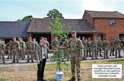  ?? ?? Daisy Lambert, site manager Boscobel House, presents an oak sapling to the Inkerman Company, Grenadier Guards