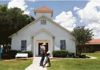  ?? Lisa Krantz / Staff photograph­er ?? Rod Green and his granddaugh­ter walk past the church in May. Green and his wife run the church’s food pantry.