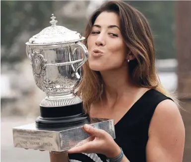  ?? Fotos: dpa ?? Paris-Siegerin Garbiñe Muguruza mit der silbernen Coupe Suzanne Lenglen.