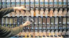  ?? FOTO: SINA SCHULDT/DPA ?? Das Symbolbild zeigt, wie in einem Unverpackt-Laden Müsli in ein Glas gefüllt wird. Die Zahl der Läden mit unverpackt­en Lebensmitt­eln im Angebot nimmt zu.