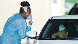  ?? DAVID SANTIAGO dsantiago@miamiheral­d.com ?? A healthcare worker teaches a person how to use a nasal swab to get tested for COVID-19 at the testing center at the Miami-Dade County Auditorium on July 23.