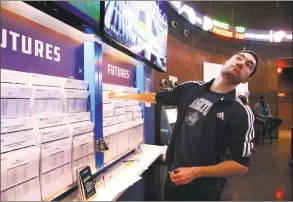  ??  ?? While checking the futures out, Michael Brandon, of Stamford, pauses to see the Texas Tech NCAA basketball game.