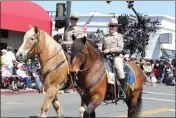  ?? ?? California Highway Patrol officers on horses wave to the crowd as the embark down First Street at the 145th Dixon May Fair's annual parade early Saturday morning.