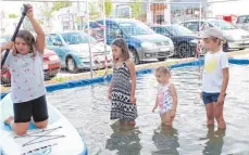  ??  ?? In der Beach-Arena bei Intersport Dietsche erfrischen sich die Kinder im Wasser.