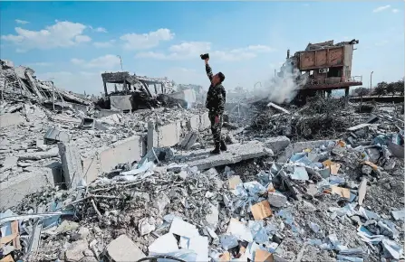  ?? HASSAN AMMAR THE ASSOCIATED PRESS ?? A Syrian soldier videos the damage to the Syrian Scientific Research Center in Barzeh, near Damascus, which was hit by U.S., British and French military strikes to punish President Bashar Assad for suspected chemical attack against civilians.