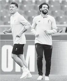  ?? ETTORE FERRARI THE ASSOCIATED PRESS ?? Liverpool players Mohamed Salah, right, and Roberto Firmino attend a team training session at the Olympic Stadium in Rome.