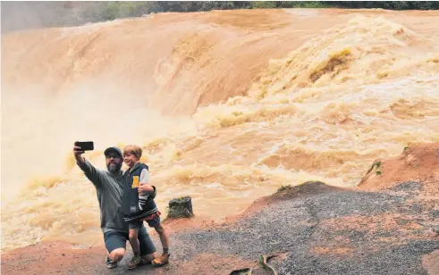  ?? Photo / File ?? A dad takes a selfie with his son of a raging waterfall. People value clear water but that can be affected by heavy rain, usch as here, as much as fencing cattle away from the waterway.