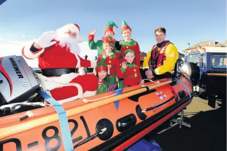  ??  ?? Water taxi for Santa The man of the moment arrives ashore at Troon