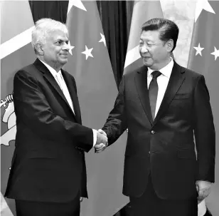  ??  ?? A file photo of Chinese President Xi Jinping (right) and Sri Lankan Prime Minister Ranil Wickremesi­nghe. Sri Lanka is among the countries where China has made investment­s guided by strategic considerat­ions