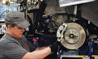  ??  ?? Facing the axe: A Vauxhall worker on the production line at Ellesmere Port