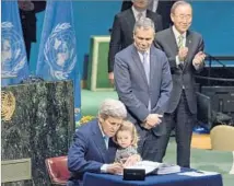  ?? Mary Altaffer Associated Press ?? THEN-SECRETARY of State John F. Kerry, with his granddaugh­ter, signs the Paris accord on behalf of the U.S. last year.