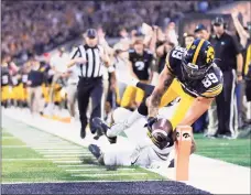  ?? Matthew Putney / Associated Press ?? Iowa wide receiver Nico Ragaini (89) dives to score a touchdown against Penn State.