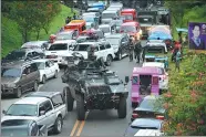  ?? TED ALJIBE / AGENCE FRANCE-PRESSE ?? An armored personnel carrier moves among vehicles of residents fleeing Marawi, Philippine­s, on Thursday.