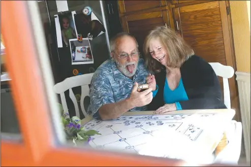  ?? (AP/Matt York) ?? Seen through their kitchen window, Allan and Debbie Cameron contact their grandchild­ren via the internet March 25 in Chandler, Ariz. Debbie, 68, has asthma which makes her one of the people most at risk from the new coronaviru­s. The Camerons now she see their children and grandchild­ren from the other side of a window or a phone.