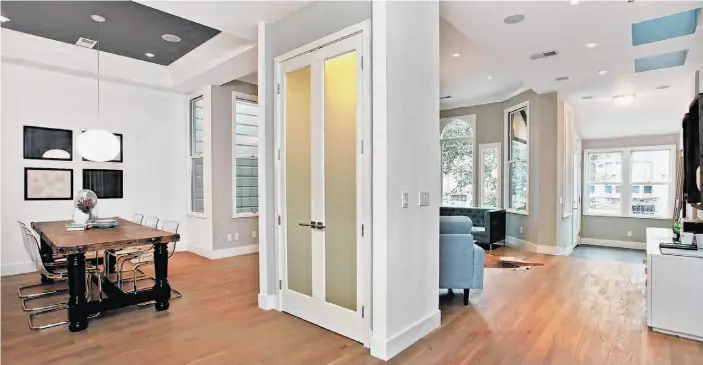  ??  ?? The lower level’s open floor plan is ideal for entertaini­ng, in addition to passing natural light and cross-ventilatio­n through the home. The front of the 11th Avenue Victorian home, below, epitomizes both its original period charm and its sleek new...